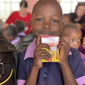 A child holding a box of crayons